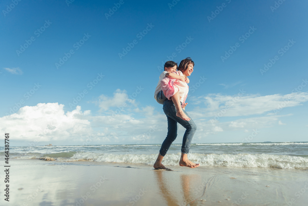 Young happy beautiful mother and her daughter having fun on the beach. Young family asian on vacation have a lot of fun Young happy beautiful mother and her daughter having fun on the beach. Young family asian on vacation have a lot of fun