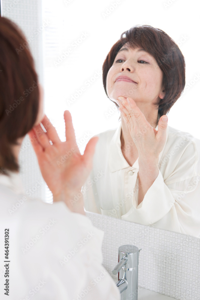 鏡を見る中高年女性 鏡を見る中高年女性