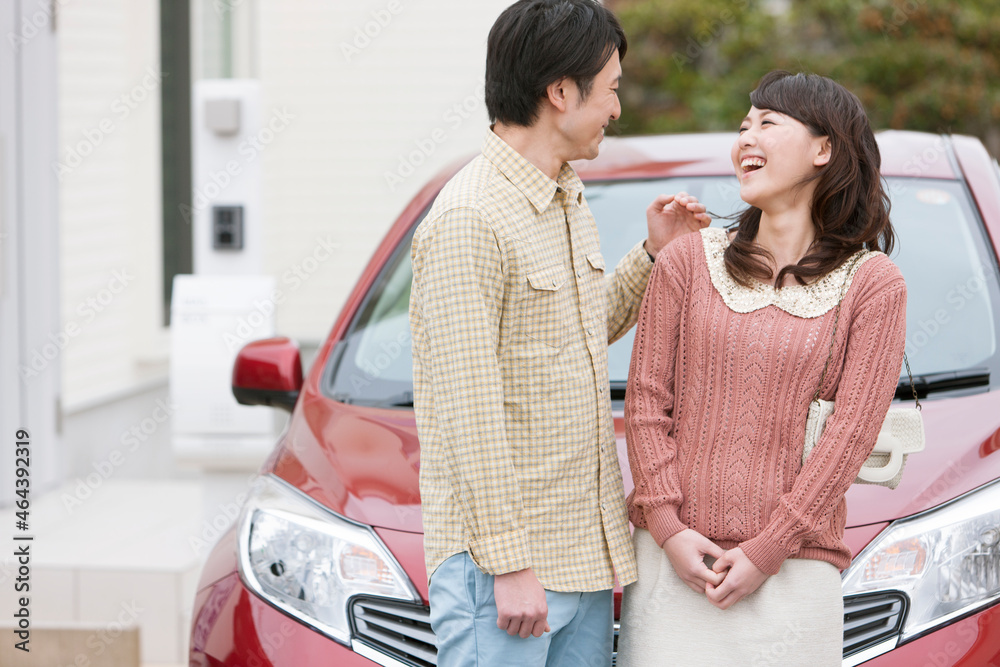 笑顔で会話する夫婦と車 笑顔で会話する夫婦と車