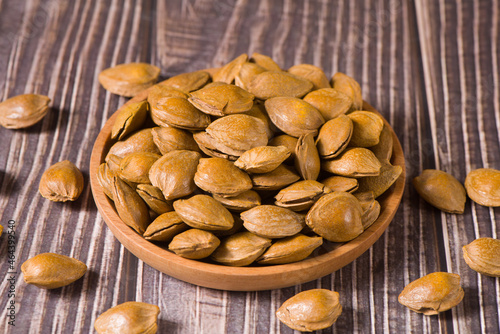 unpeeled almonds on wood background