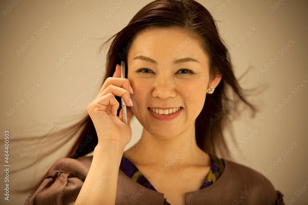 スマートフォンで電話する中高年女性 スマートフォンで電話する中高年女性