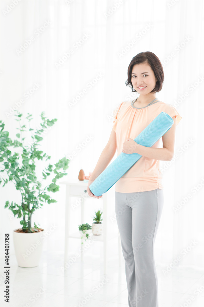 ヨガマットをもつ女性