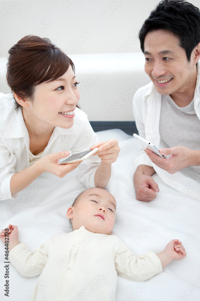 赤ちゃんの写真を撮る両親 赤ちゃんの写真を撮る両親