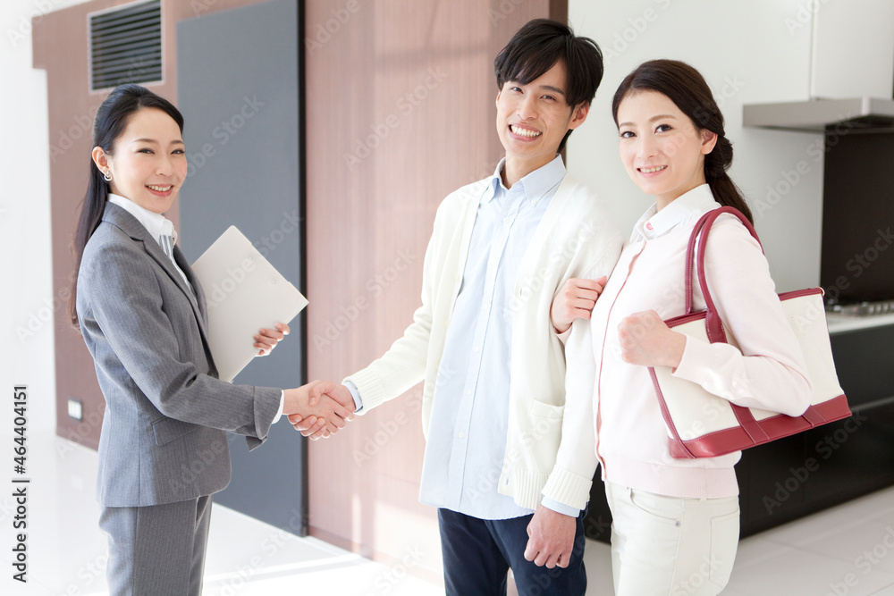 握手するビジネスウーマンと夫婦