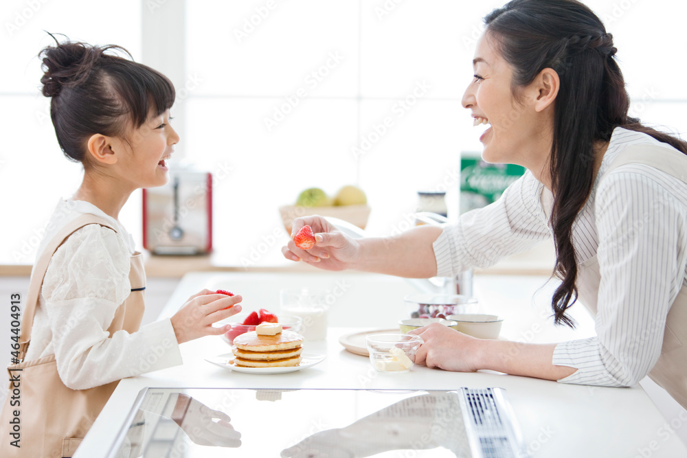 イチゴを持つ女の子と母親 イチゴを持つ女の子と母親