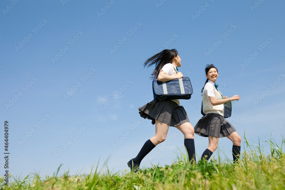 芝生を走る女子校生2人