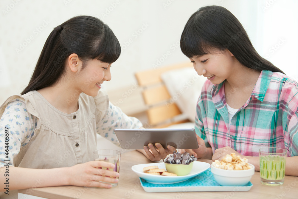 タブレットPCを見て話す女の子2人 タブレットPCを見て話す女の子2人