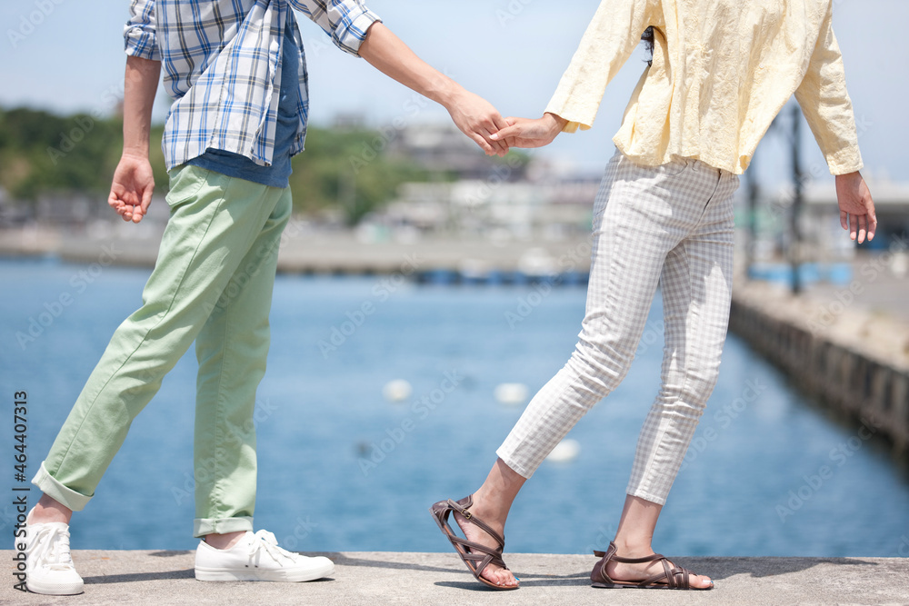 海岸で手をつなぐカップル