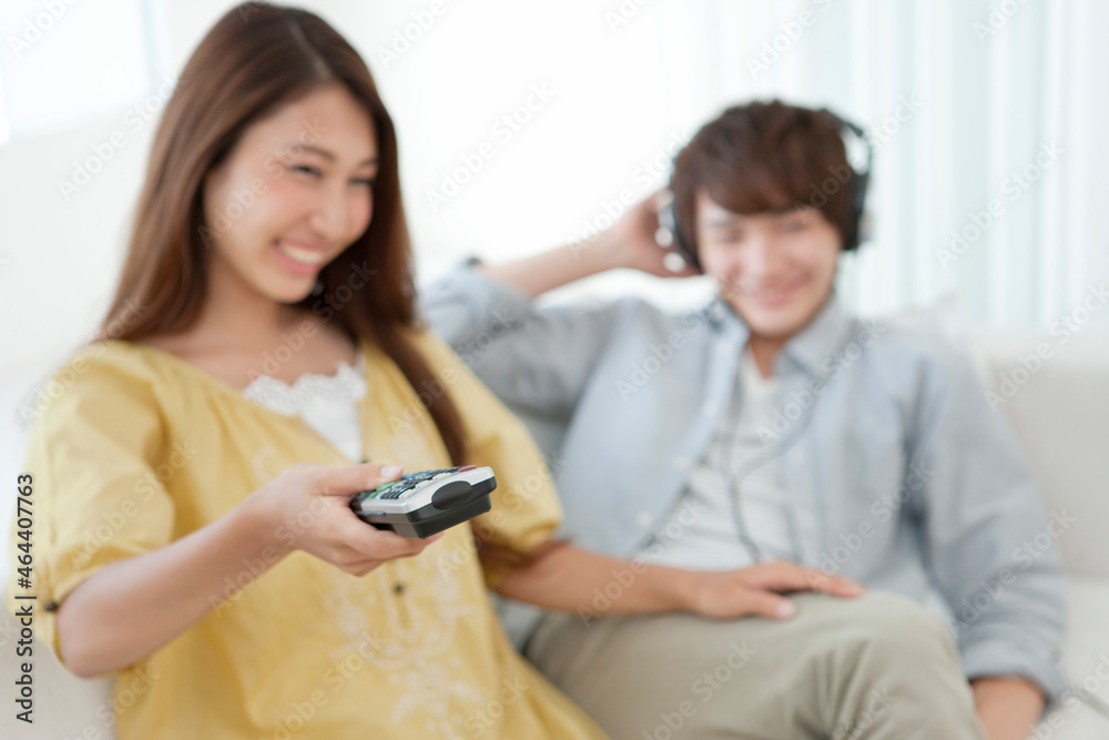テレビのリモコンを操作する女性の手元 テレビのリモコンを操作する女性の手元