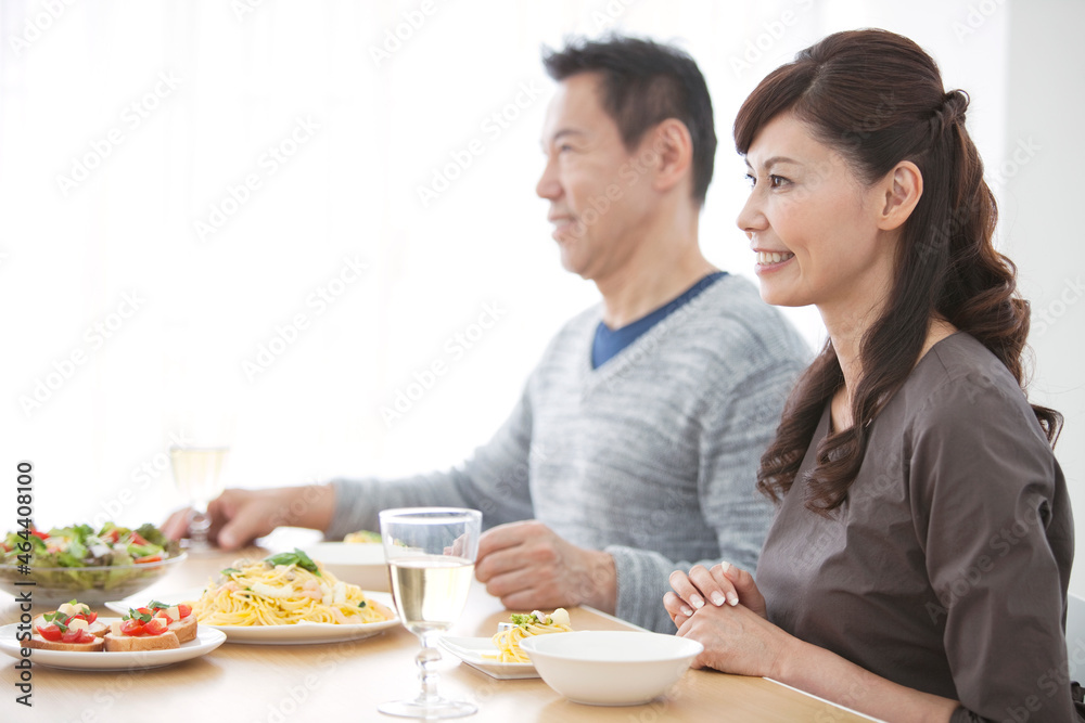 食卓に座る笑顔の中高年夫婦