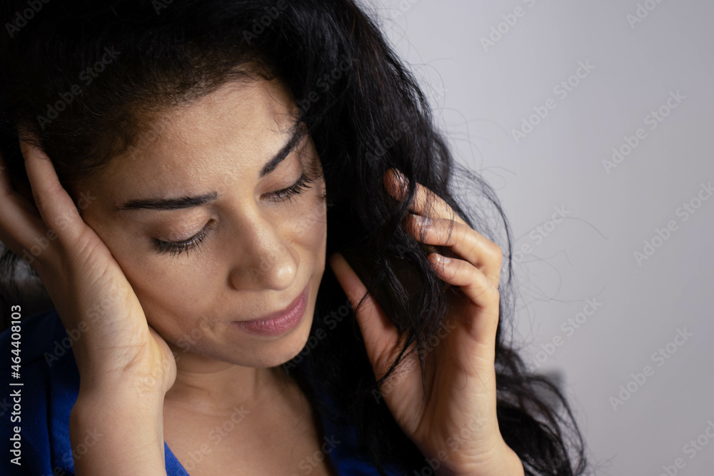 Busy executive on the phone with her work group, dressed in blue in commemoration of Blue Monday and happy running her business from home. Image left side.