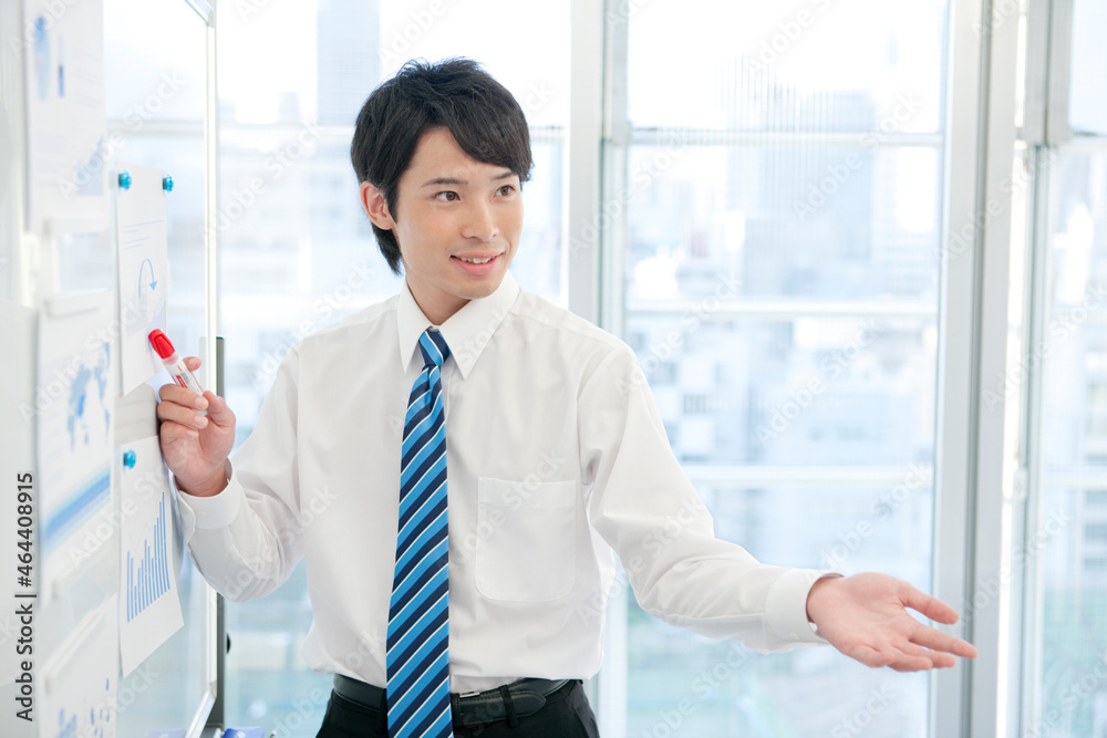 ホワイトボードの前に立つビジネスマン