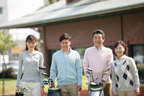 ゴルフバッグを持って立つ家族4人 photo