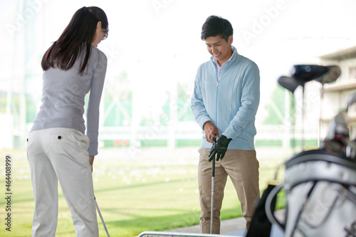 女性にゴルフを教える男性 photo