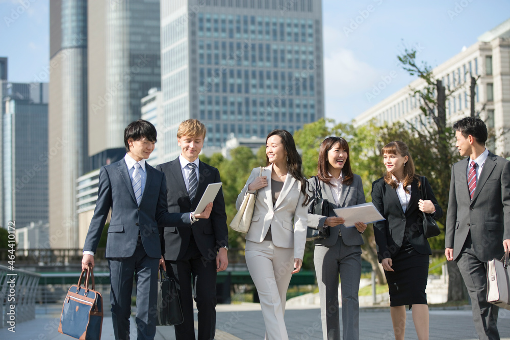 オフィス街を歩くビジネスマンとビジネスウーマン6人