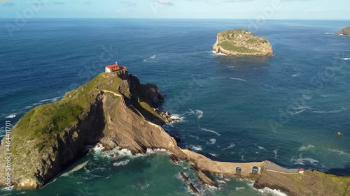 Aerial view of Gaztelugatxe  scenic hermitage dedicated to John the Baptist in Spain Basque Country. Drone fly above the old church on the cliff in the ocean. photo