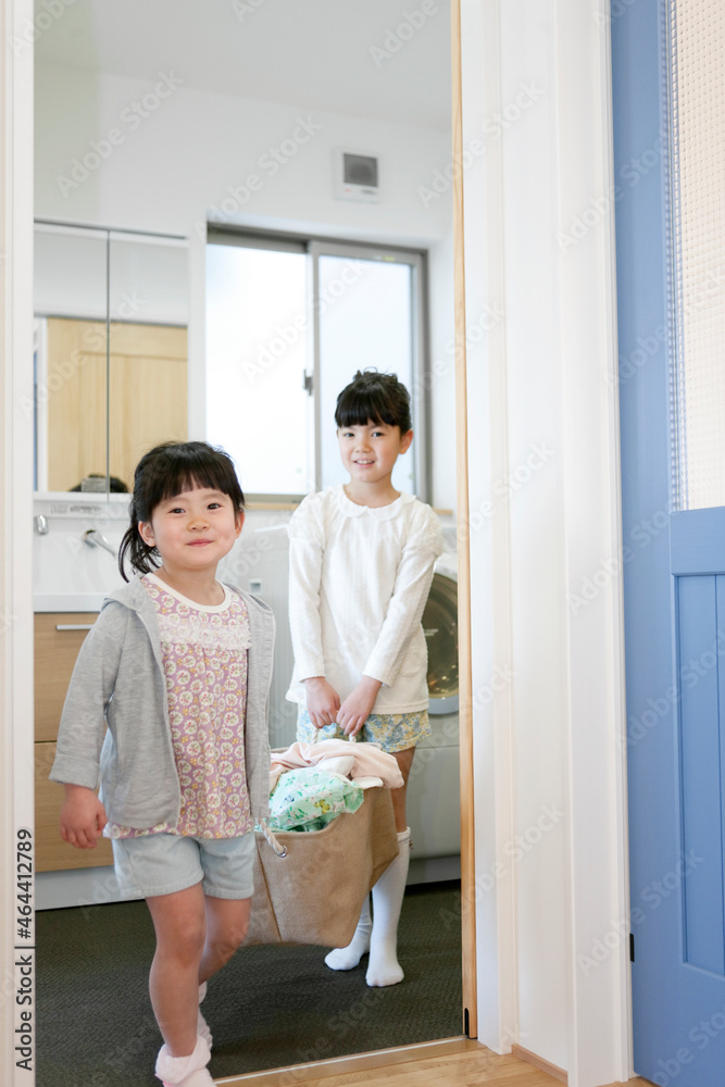 洗濯物を運ぶ姉妹
