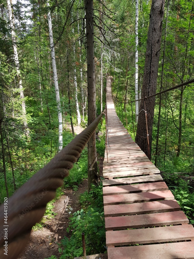Old wooden pedestrian bridge in the forest Old wooden pedestrian bridge in the forest