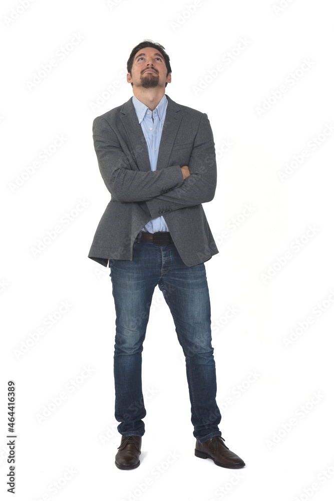front view of a man with blazer and jeans with arms crossed looking up on white background front view of a man with blazer and jeans with arms crossed looking up on white background