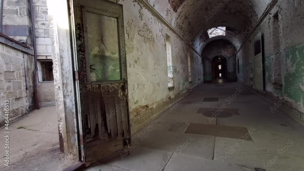 Camera moves down decrepit corridor to central hub (panopticon) of prison. Camera moves down decrepit corridor to central hub (panopticon) of prison.