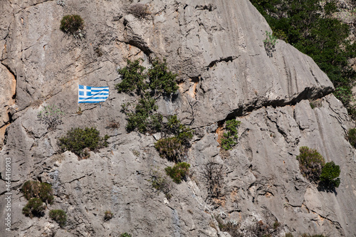 Greek flag on hill stone wall