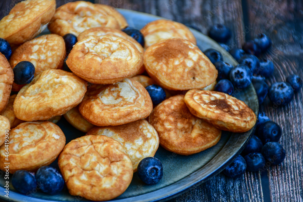 Homemade Dutch Poffertjes Mini Pancakes with butter , Powdered Sugar and blueberries Homemade Dutch Poffertjes Mini Pancakes with butter , Powdered Sugar and blueberries