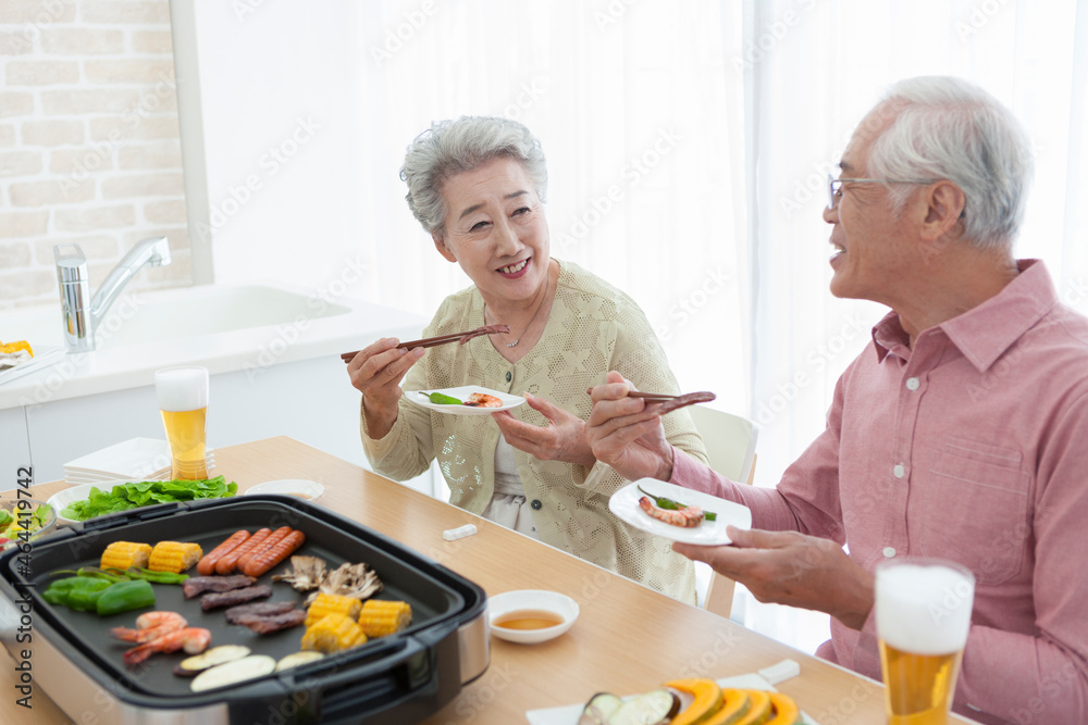 焼肉を食べるシニア夫婦 焼肉を食べるシニア夫婦