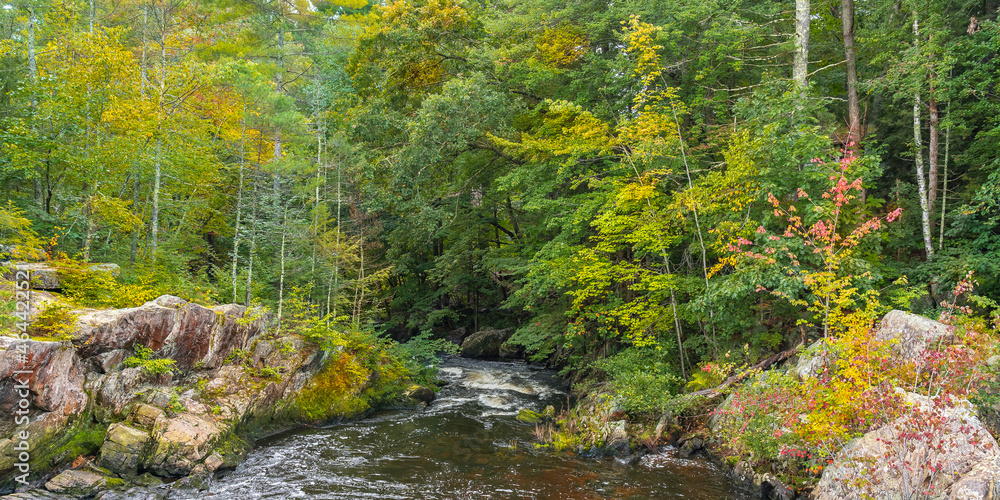The Ammonusuk mountain river stream among granite stones in an autumn forest, flowing from Mount Washington in the White Mountain National Forest in New Hampshire. The Ammonusuk mountain river stream among granite stones in an autumn forest, flowing from Mount Washington in the White Mountain National Forest in New Hampshire.