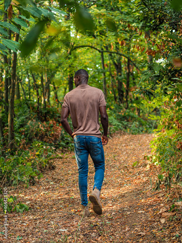 fit tall young african man from behind relaxing and  walking in the forest photo