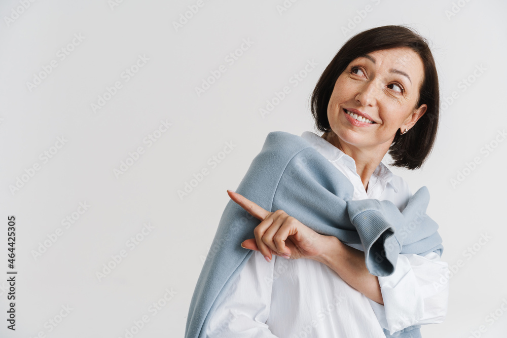 Fototapeta premium European mature woman smiling and pointing finger aside