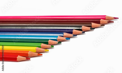 Colored pencils lie in a row on a white background