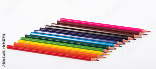 a set of colored pencils lies in a row on a white background