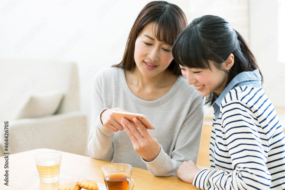 スマートフォンを見る親子 スマートフォンを見る親子