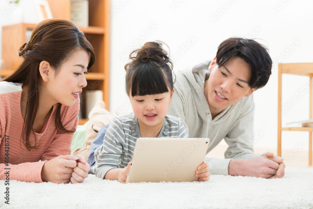 タブレットPCを見ている家族3人 タブレットPCを見ている家族3人