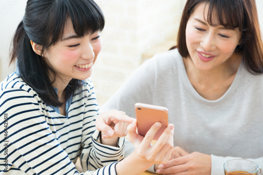 スマートフォンを見る親子 スマートフォンを見る親子