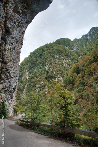 Wallpaper Mural The mountain road runs along the cliff at the cliff. Rocks hang over the road and the abyss. Torontodigital.ca