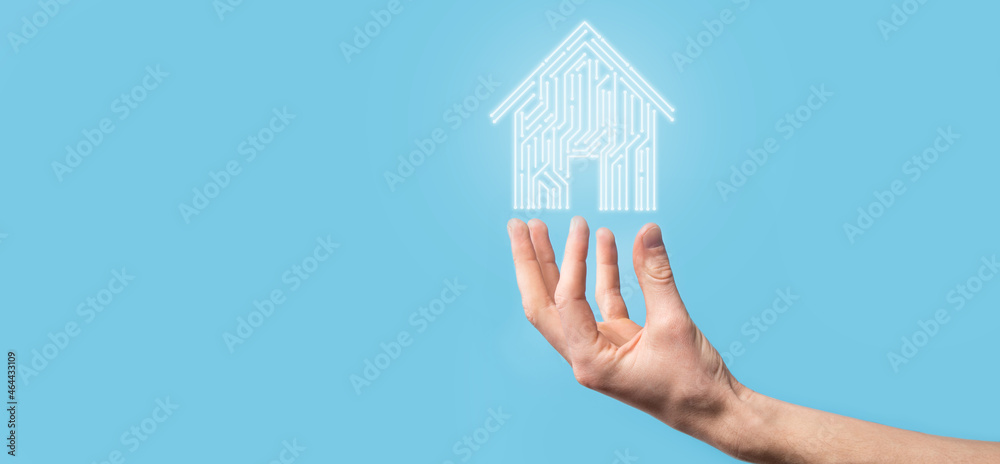 Naklejka premium Hand hold house icon.Smart home controlled, intelligent house, and home automation app concept.Pcb design and person with smart phone. Innovation technology internet Network Concept.