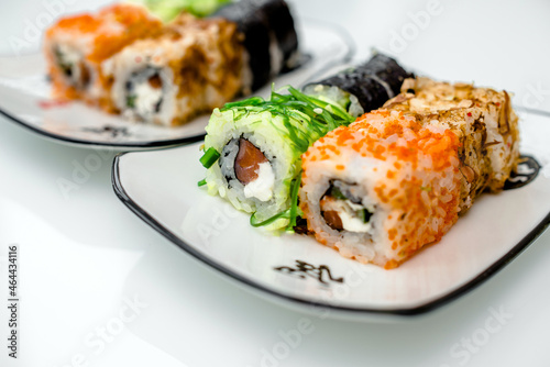Several sushi on a white plate standing on a white background 