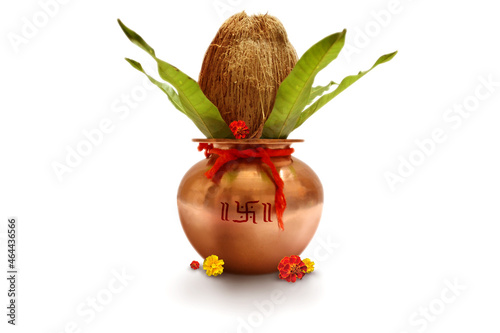 Indian festival akshaya tritiya, Wedding concept : Decorative Copper kalash with coconut and mango leaf with floral decoration on a white background. Essential in Hindu Puja. photo