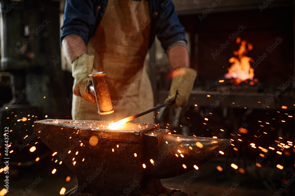 Close-up of blacksmith manually forging the molten metal in the workshop Close-up of blacksmith manually forging the molten metal in the workshop