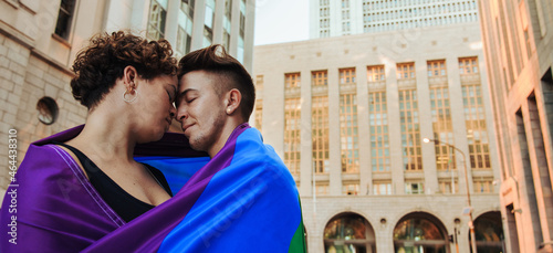 Quadro em tela LGBTQ+ couple standing with a rainbow flag around them