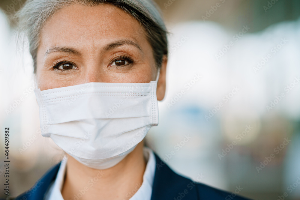 Grey asian woman looking at camera while posing in face mask Grey asian woman looking at camera while posing in face mask