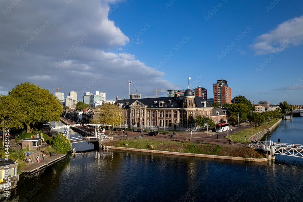 Aerial showing Muntgebouw museum in Utrecht with small draw bridge over the canal in front on a bright sunny day with cloud formation in the background. Dutch urban scenery.