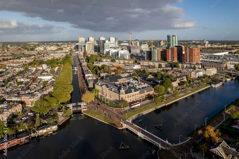 Fototapeta premium Muntgebouw and skyline of Dutch city Utrecht with financial and central train station area in the background with canal and floating homes in the foreground