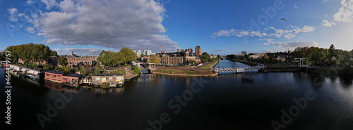 Wide panorama of canal in Utrecht with floating home boats and Muntgebouw against a blue sky with cumulus clouds above. Urban housing  cityscape.