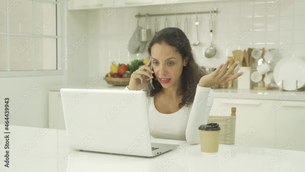 Relax happy latin young businesswoman. People talking on smartphone on social media internet and using a computer laptop notebook technology device in kitchen at home. Lifestyle
