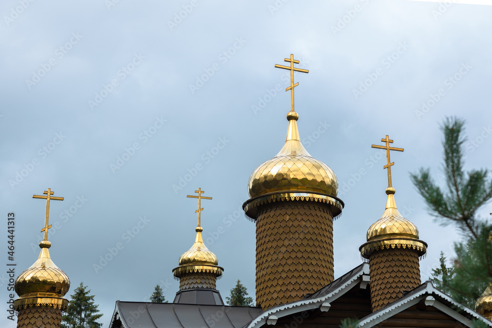 Golden domes on a wooden old church, Orthodox Christian temple, Easter background, faith in God