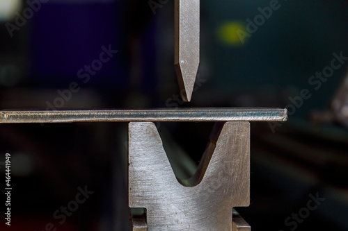 Work on a CNC bending machine in a factory. Sheet metal bending on a high-precision sheet metal bending machine. photo