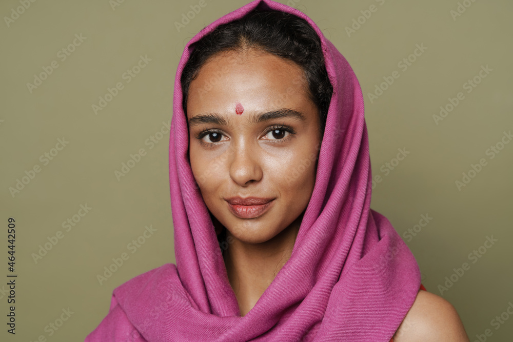 Young south asian woman in headscarf smiling while looking at camera Young south asian woman in headscarf smiling while looking at camera