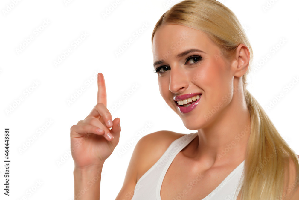 Pretty young happy woman point finger up and smile Pretty young happy woman point finger up and smile